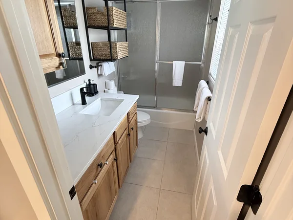 Bathroom vanity, mirrors, and tile detail cleaned