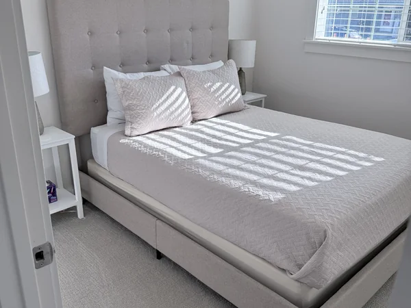 Bedroom cleaned with bed, carpet, and visible surfaces reset